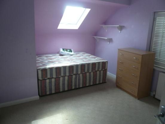 The room has a double bed, built in wardrobe, built in desk, sky window and is very spacious. it has cream walls unlike the photo