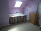 The room has a double bed, built in wardrobe, built in desk, sky window and is very spacious. it has cream walls unlike the photo