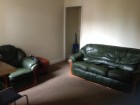 This is spacious communal area has a sofa, chairs, table and a TV with Sky TV.