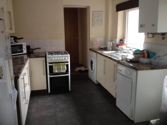 This kitchen area features a washing machine, tumble drier, fridge freeze units, a microwave, gas cooker, sink and draining area, and designated cabinets for each tennant. 