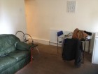 This is spacious communal area has a sofa, chairs, table and a TV with Sky TV.